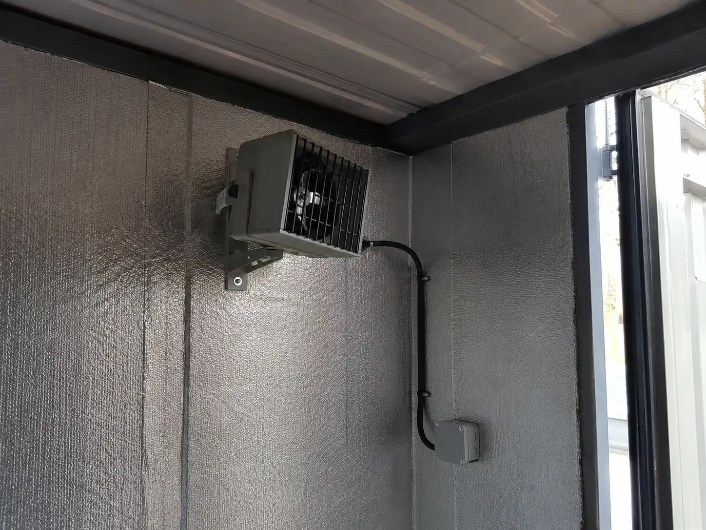 Elektrischer Frostwächter an der Innenwand eines gedämmten Lagercontainers