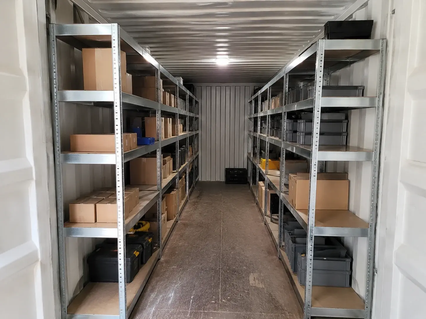 Fachbodenregale an beiden Seiten mit freiem Mittelgang im Lagercontainer