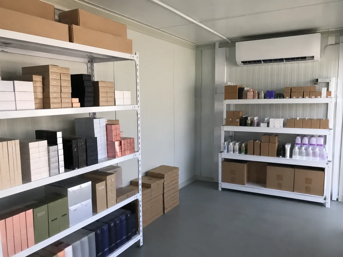 Gedämmter Lagercontainer mit Klimagerät und temperaturempfindlicher Ware in Regalen